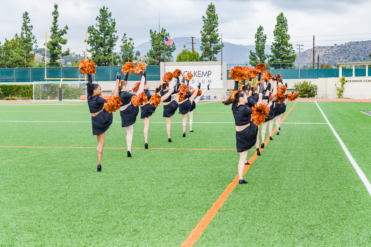 Oxy cheer squad leads a cheer on Patterson Field