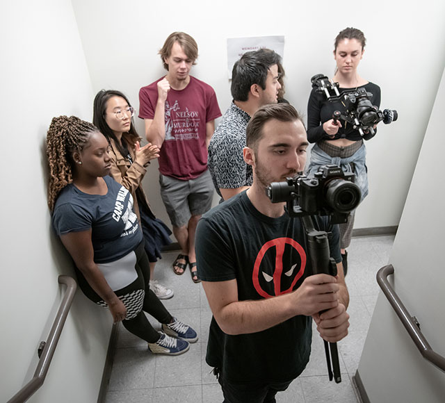 MAC students stand in a hallway with digital camera equipment