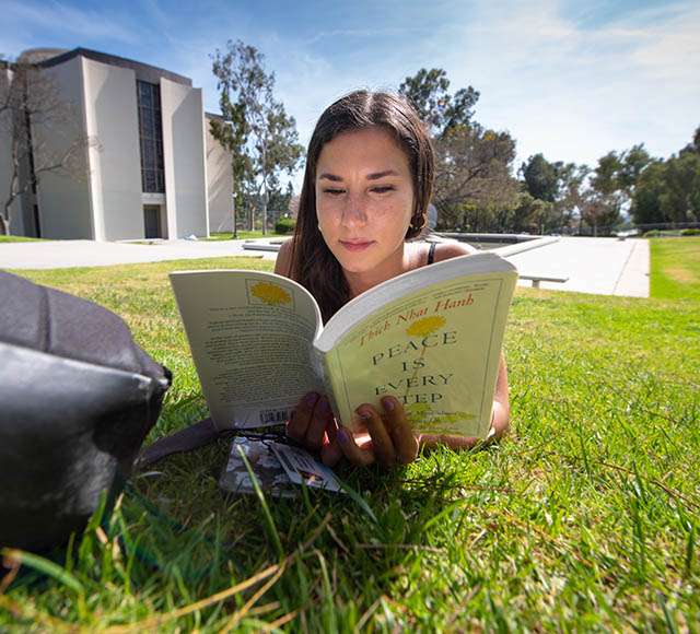 Student studying on the lawn