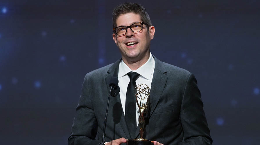 Professor Adam Schoenberg holds his Emmy award