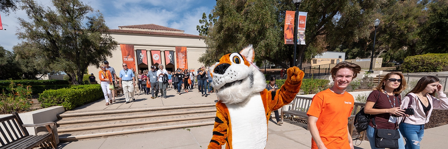 Oswald the Tiger strolls in front of Thorne Hall with students, alumni, and families