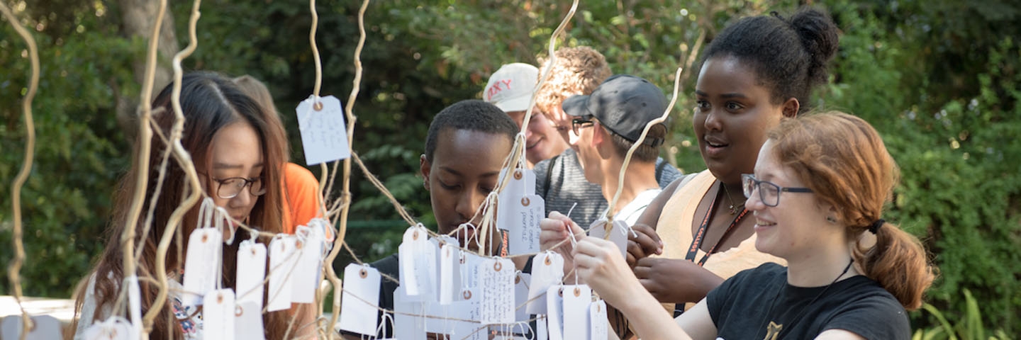 A diverse group of students interacting together on an art project