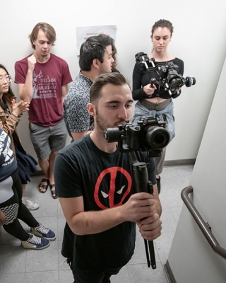 MAC students stand in a hallway with digital camera equipment